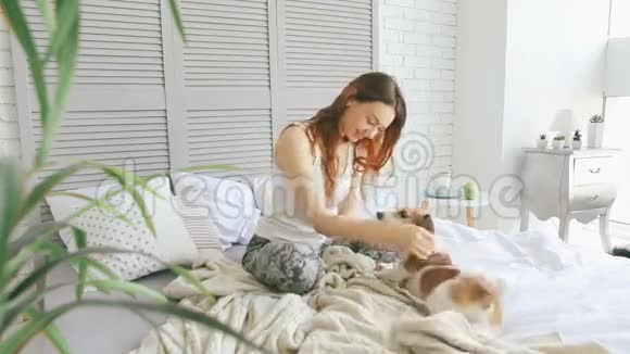一个女人在床上玩宠物视频的预览图
