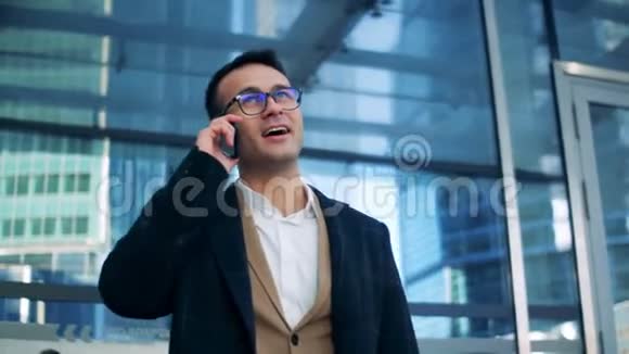 商人站在一个商务中心附近微笑着在电话里交谈红色史诗影院镜头拍摄视频的预览图