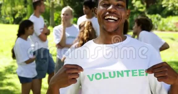 英俊的志愿者把他的t恤拍照视频的预览图