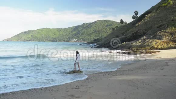 可爱的女孩在蓝天下的亚努伊海滩玩波浪视频的预览图