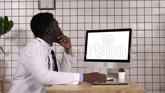 年轻的非洲医生在看他电脑的显示器白色显示器视频的预览图