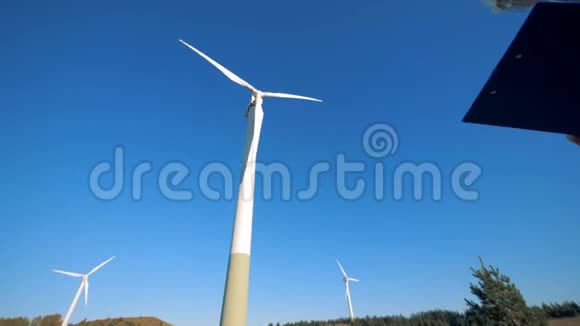 旋转风力涡轮机和一名男性专家站在他们附近清洁环保的能源理念视频的预览图