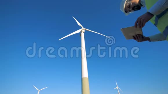 一位男性专家正在观察风力发电机清洁环保的能源理念视频的预览图