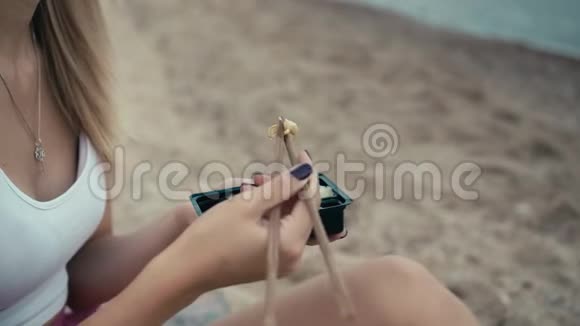 一个年轻的白种人女孩用日本筷子把生姜放进嘴里嚼了之后玩得开心视频的预览图