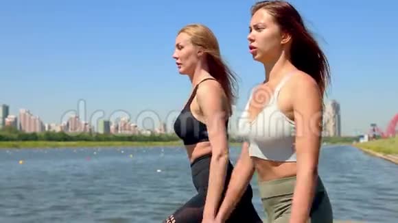 两个女人在城市的河岸上做运动户外运动视频的预览图