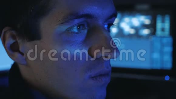 黑客程序员在电脑上工作的肖像而蓝码字符在网络安全中心的脸上反射视频的预览图