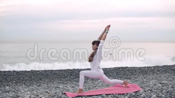 清晨时分女人在鹅卵石海岸放松瑜伽体式视频的预览图