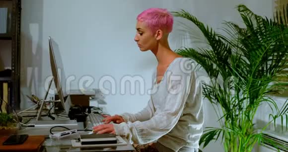 粉红头发的女人在电脑上工作4k视频的预览图