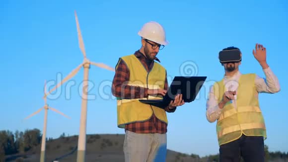 风车领域与两名男性专家测试虚拟现实眼镜清洁环保的能源理念视频的预览图