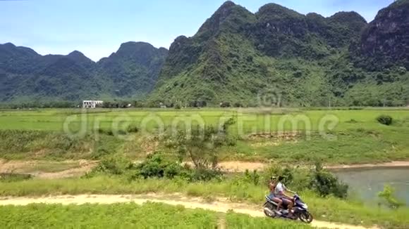 女孩骑着摩托车沿着小河行驶视频的预览图
