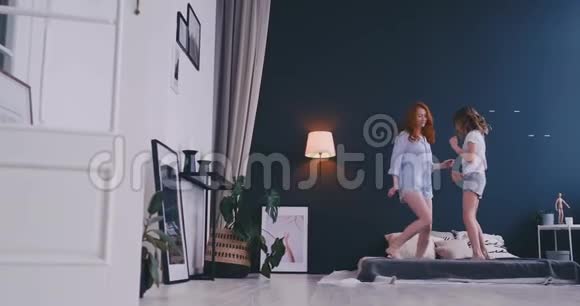可爱的小女孩和她可爱的母亲一起玩跳舞现代风格一起跳在床上给高五视频的预览图