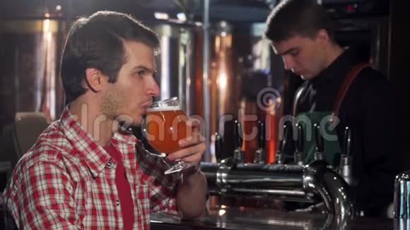 快乐的年轻人在酒吧休息喝着美味的啤酒视频的预览图