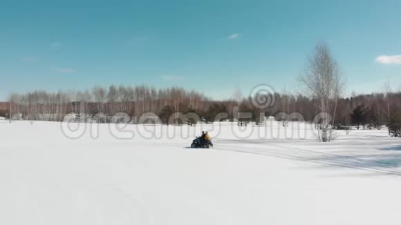一个男人和一个女人坐在ATV上冬天的雪视频的预览图