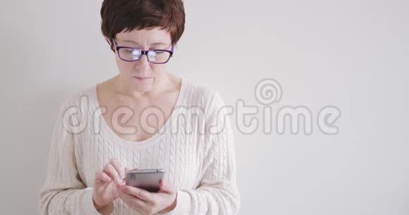 布鲁内特女士戴着眼镜带着白色背景的电话视频的预览图
