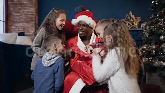 可爱的圣诞老人在帽子打开包与礼物给儿童视频的预览图