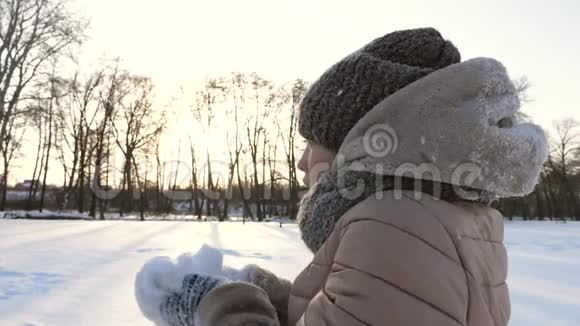 少女在冬天的公园里把白雪抛起来微笑圣诞节在寒冷的日子里举行雪的运动会视频的预览图
