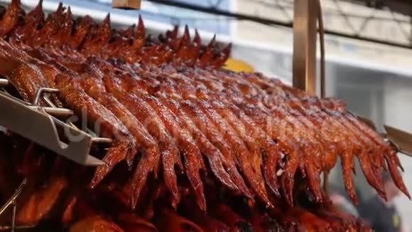 厨房里的金属串上挂着许多煮熟的鸡肉亚洲泰国日本东方美食视频的预览图