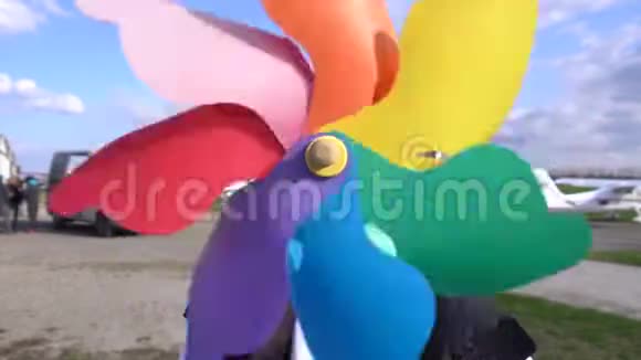 彩虹彩色旋转风车在草地上视频的预览图