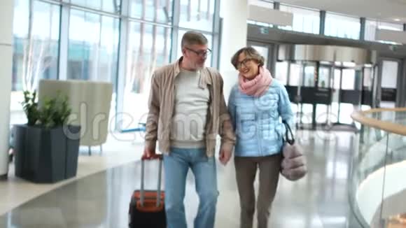 夫妻俩在机场退休他们着陆了聊得很开心期待着愉快的旅行视频的预览图