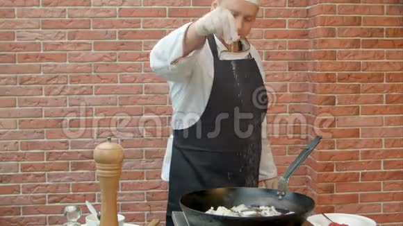 厨师把盐和胡椒放入锅中煮海鲜视频的预览图