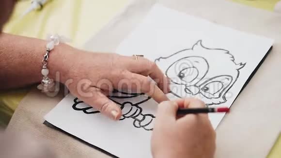 一个女人在白色的床单上画了一幅猫头鹰的酷画她双手合拢视频的预览图