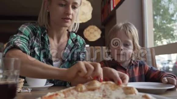 女人和5岁男孩在咖啡馆吃披萨视频的预览图