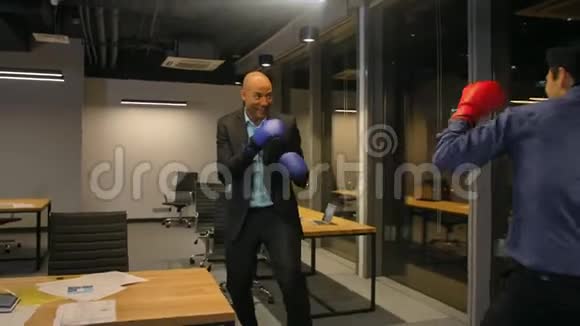 两个在公司办公室打拳击的有竞争力的商人视频的预览图