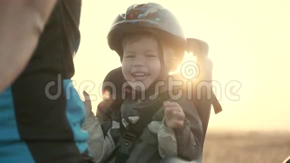 一个23岁的男孩戴着头盔坐着儿童自行车座椅黎明家庭自行车步行视频的预览图