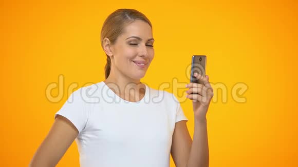 快乐的女性竖起大拇指手持智能手机上网购物上网视频的预览图