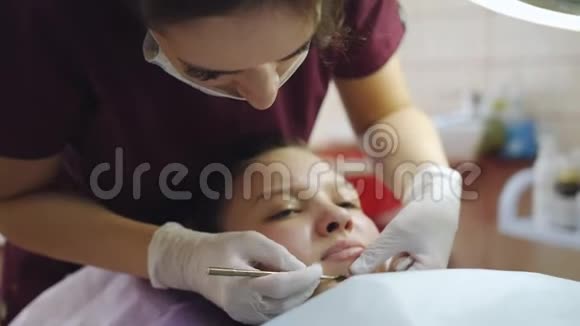 美容院的医生美容师把脸上的青春痘从女孩清洁到青少年视频的预览图