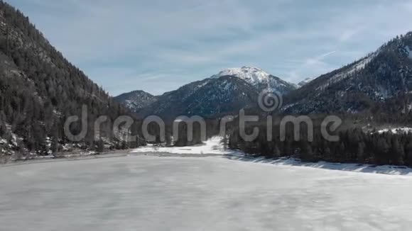 在冬季山脉之间的冰场上进行旅游旅行旅行时使用云杉对抗蓝天视频的预览图