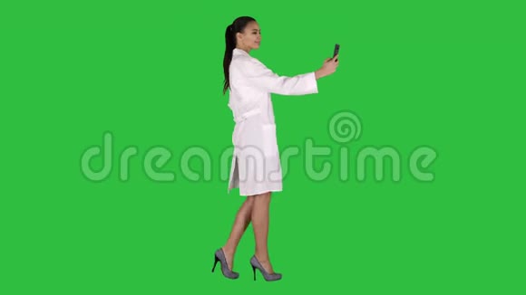 时尚的欧洲医生黑发在电话自拍而走在绿色屏幕Chroma键视频的预览图