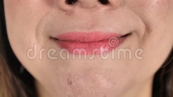 用唇膏嘴唇贴紧女人的肖像微笑慢动作视频的预览图