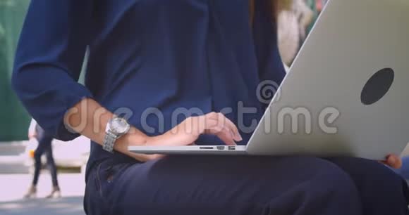 城市户外公园里年轻的高加索女商人在笔记本电脑上打字的特写照片视频的预览图