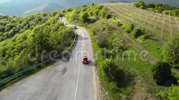 一辆红色复古汽车在蛇形公路上的俯视图视频的预览图