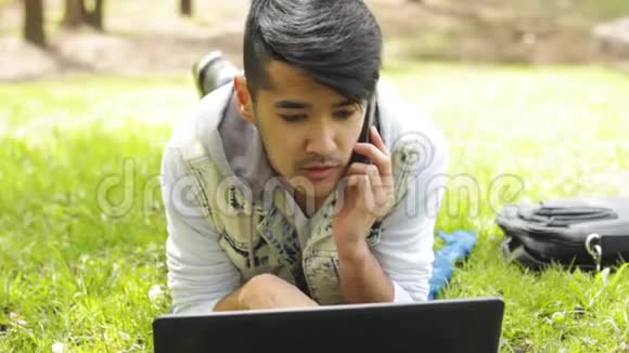 亚洲男人打电话看笔记本电脑视频的预览图