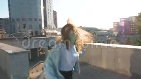 棕色头发的女人留着长发在阳光的背景下跳跃和跳舞视频的预览图