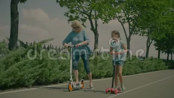 奶奶和孙女在公园里骑摩托车视频的预览图