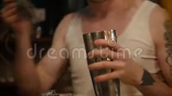 年轻的职业酒保把白色的奶油饮料倒入满是冰的杯子里视频的预览图