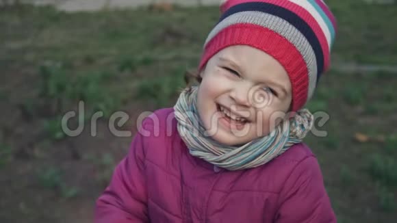 一个美丽的白人小女孩带着美丽的蓝色眼睛戴着条纹帽子微笑着快乐的童年视频的预览图