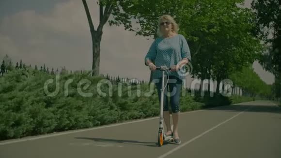 积极主动的老年妇女在公园骑滑板车视频的预览图