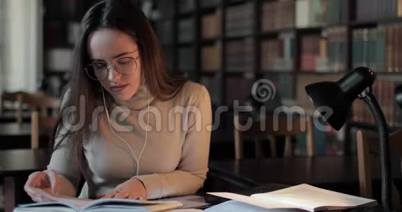 在图书馆学习和打字的女孩视频的预览图