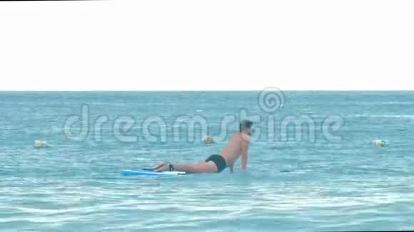 人躺在漂浮在蓝海中的桨盘上视频的预览图