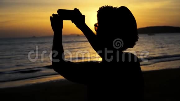 带帽子的年轻男性旅行背包客回影照夏日海滩景色与日落旅行视频的预览图