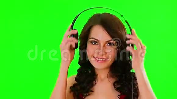 戴耳机的女孩听音乐绿色屏幕视频的预览图
