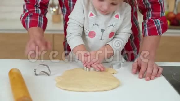幼儿女孩和她父亲一起切饼干视频的预览图