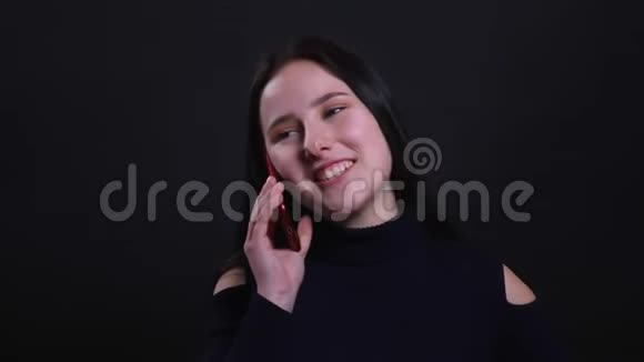 年轻漂亮的黑发女性的特写照片她打电话时兴高采烈地笑着背景则被隔绝在外视频的预览图