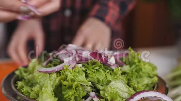 把紫色洋葱掉在盘子里配上沙拉慢动作视频的预览图