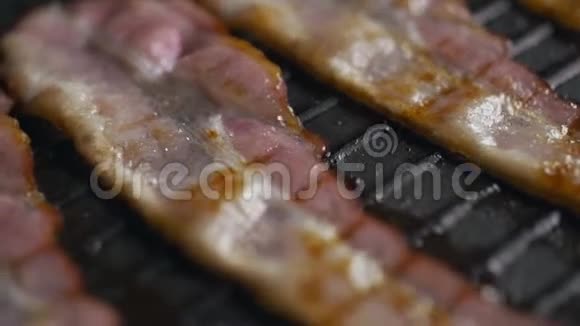 烤火烤盘上烤的大块培根慢镜头烤培根肉片上烤视频的预览图