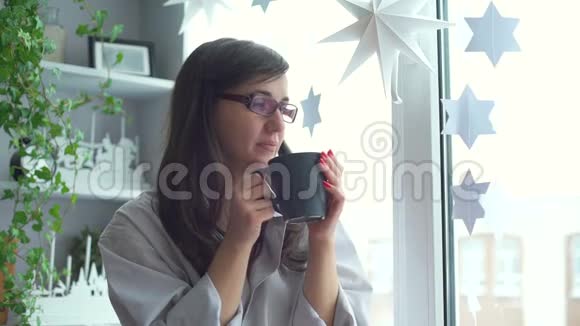 女人在窗台上喝热茶视频的预览图